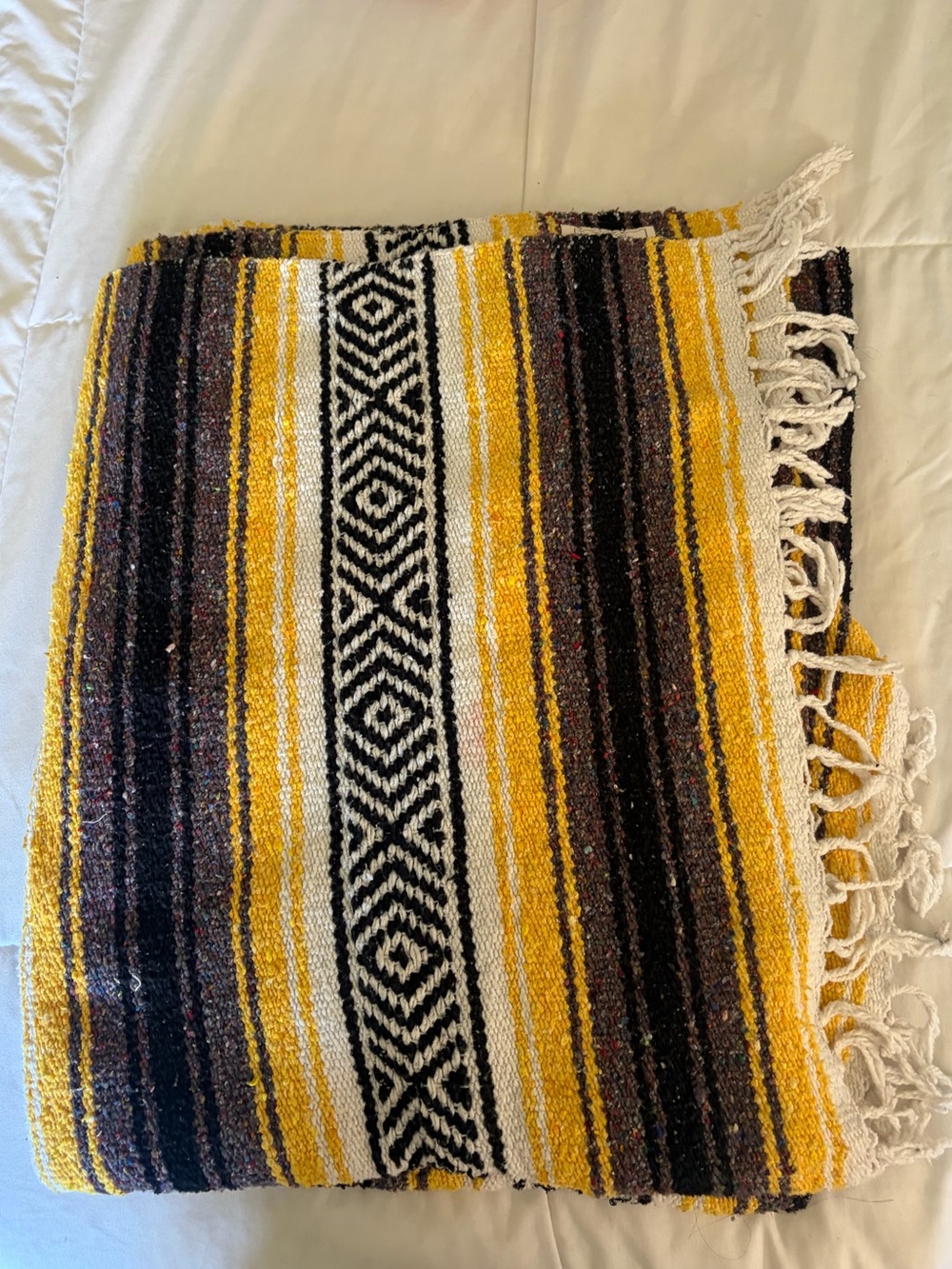 Yellow, black, and white striped blanket with geometric diamond pattern